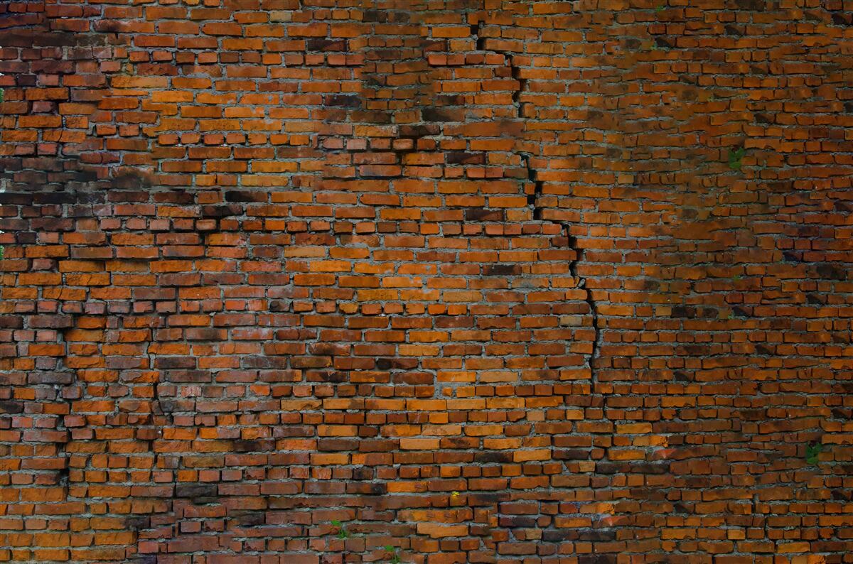 Carta da parati grande crepa in un muro di mattoni