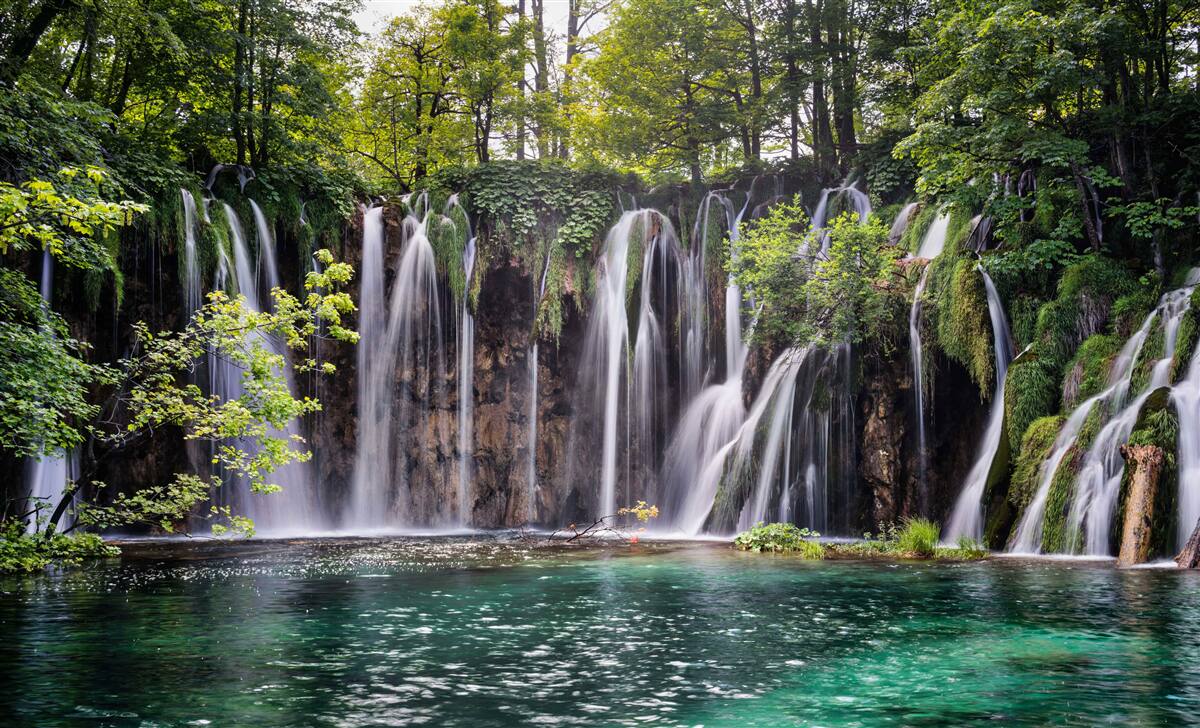 Carta da parati cascate che sfociano in un lago limpido