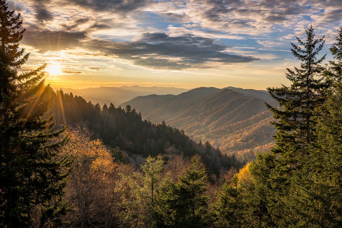 Carta da parati il sole che tramonta sulle cime delle montagne
